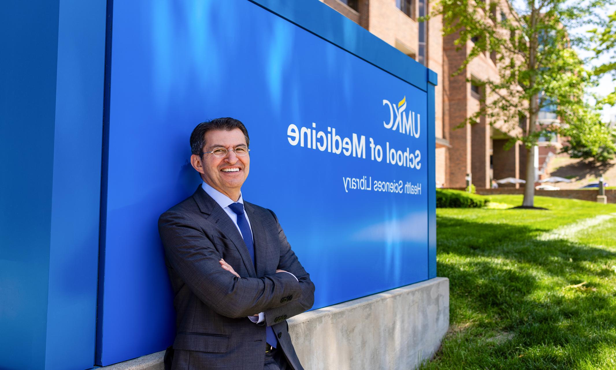 Dean Norbash standing next to School of Medicine sign